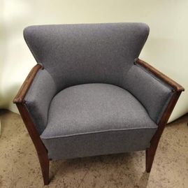 omtrekking av en grå stol med tre detaljer på armlenene og stolbenene 