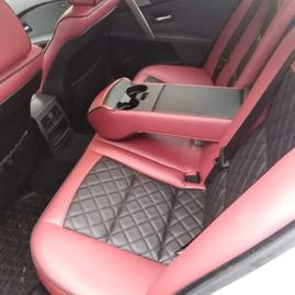 Baksetene på en bil som er røde med sorte detaljer i midten av setene med kryvsmønster sett fra siden