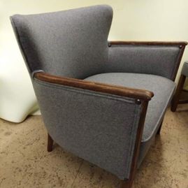 omtrekking av en grå stol med tre detaljer på armlenene og stolbenene 