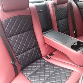 Baksetene på en bil som er røde med sorte detaljer i midten av setene med kryvsmønster